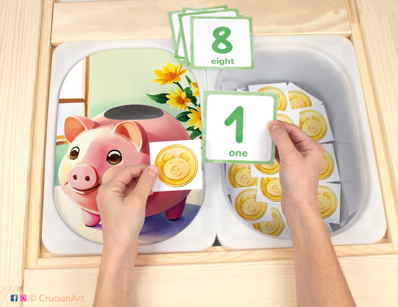 Piggy Bank theme Flisat insert resource in a Montessori preschool: early math counting activity placed on an IKEA Children's Sensory Table. Funny illustration for kids sensory table insert.