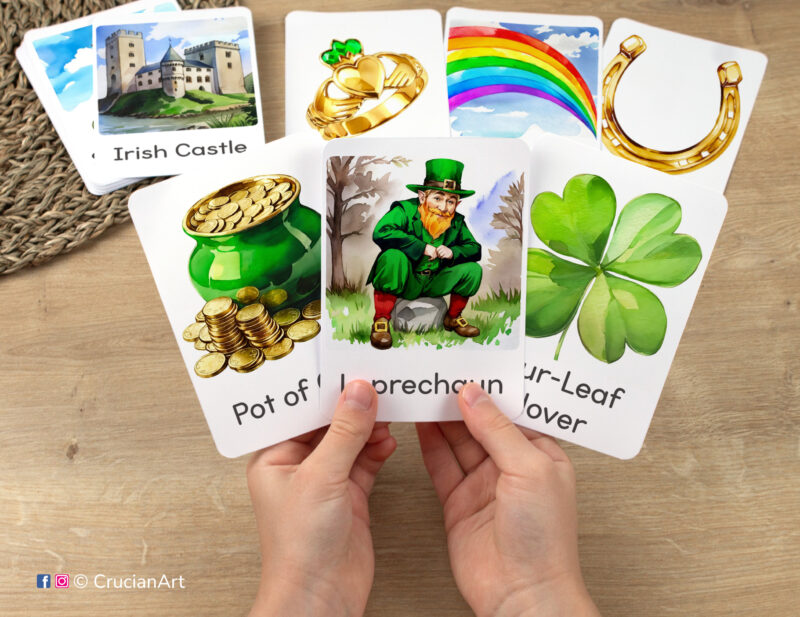 Flashcards featuring watercolor illustrations of Leprechaun, Pot of Gold, and Four-Leaf Clover in toddler's hands.