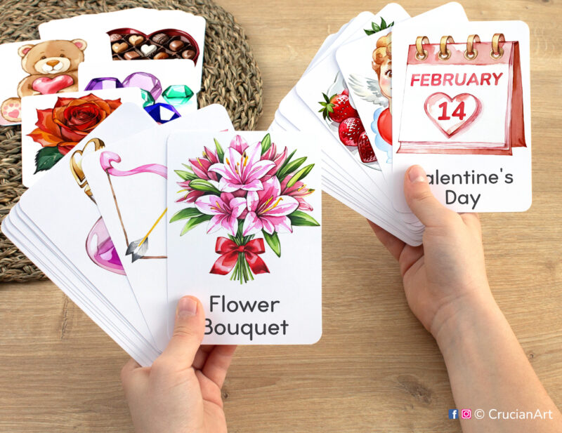 Preschooler hands holding Saint Valentine Day flashcards with watercolor images of February 14th Date and Flower Bouquet