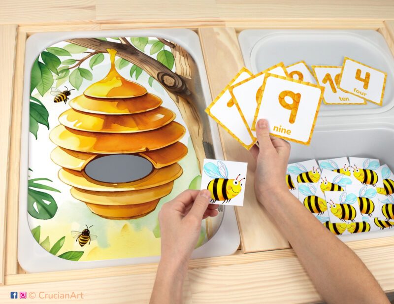 Bee hive theme toddler play for sensory bins. DIY template inserted into IKEA Flisat table, with honeybees counters placed in the Trofast box.