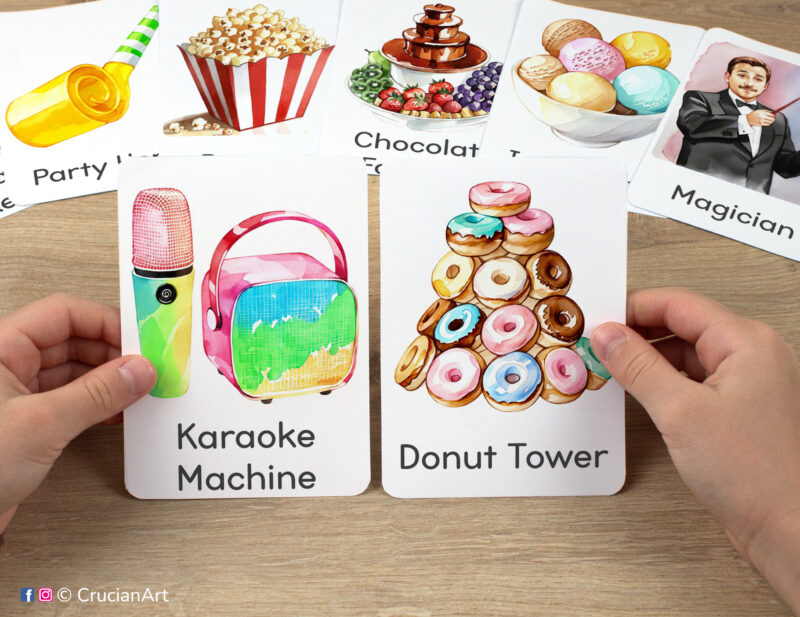 Preschooler hands holding birthday party themed flashcards with watercolor images of a donut tower and a karaoke machine. Printable preschool materials for pre-reading activity.