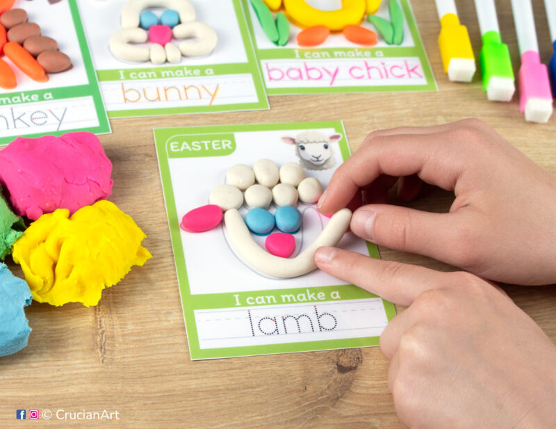 A preschooler is playing with play-doh, molding an Easter lamb. Easter playdough mats for toddlers fine motor skill development.