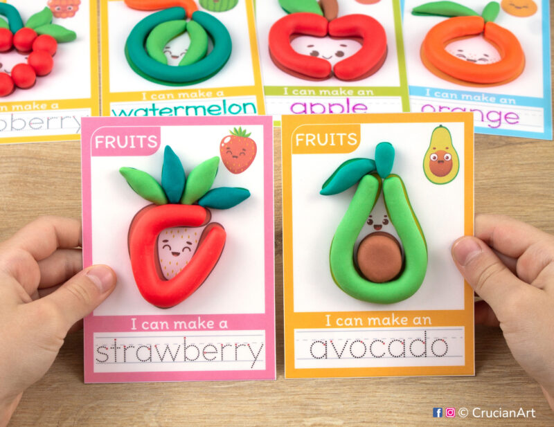 Fruit and Berry hands-on play-doh activities for preschool and toddler curriculum. Preschooler holds two playdough mats with images of a strawberry and an avocado.