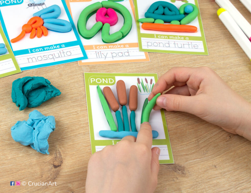 A preschooler is playing with play-doh, molding a cattail. Pond habitat and pond animals playdough mats for toddlers fine motor skill development.