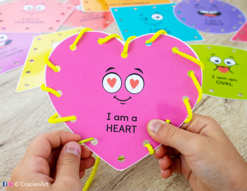 DIY lacing cards with two-dimensional shapes and their names. Preschooler tying a heart shape with a lace. Educational printables for toddler curriculum.