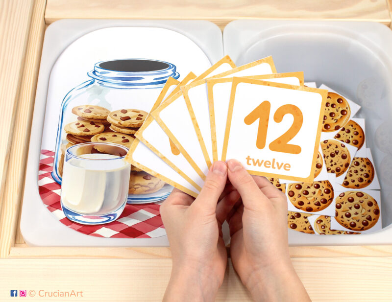 Cookie jar fill-up pretend play setup. Sensory table insert and kids hands holding task cards displaying numerals from 1 to 12. Printable activity for chocolate chip cookies curriculum.