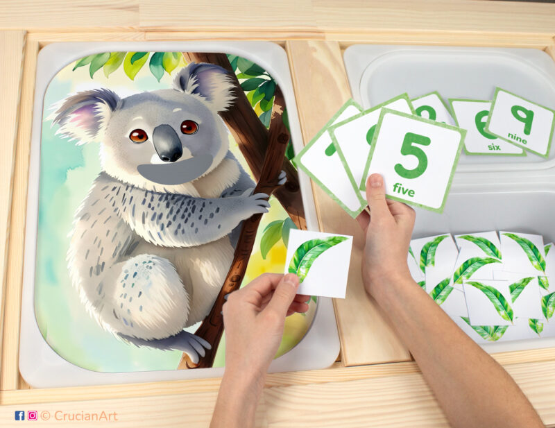 Feed the koala eucalyptus leaves sensory bins play for toddlers: animals of Australia theme worksheet for an educational activity. DIY template inserted into ikea flisat table, with counters placed in the trofast bin.