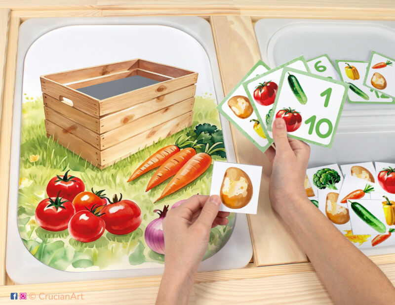 Toddler sensory play: vegetable box and veggies worksheet for an educational counting activity inserted into IKEA Flisat table and counters with tomato, cucumber, bell pepper, broccoli, carrots, potatoes placed in the Trofast bin.