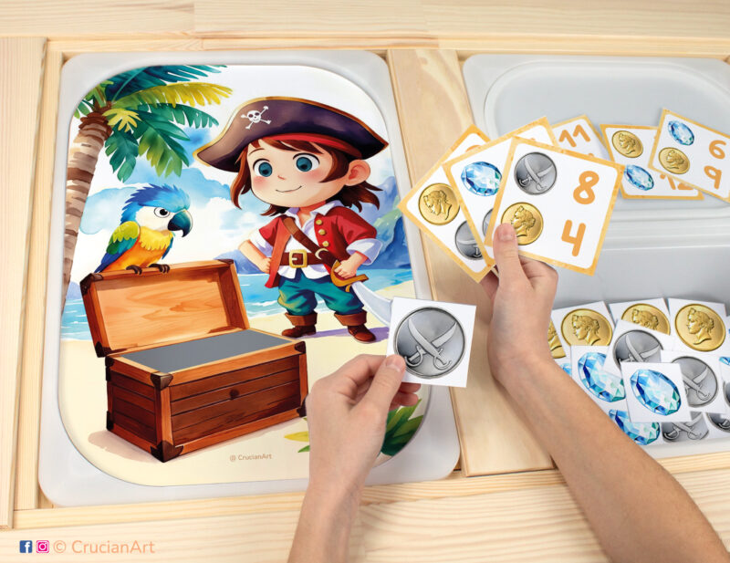 Pirate's treasure chest worksheet for an educational counting activity inserted into IKEA Flisat table and counters with gold doubloon, silver doubloon and gems placed in the Trofast bin.