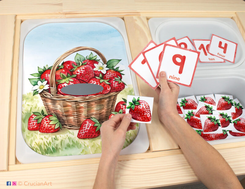 Strawberry berries in the garden sensory bins play for toddlers: summer season worksheet for an educational activity. DIY template inserted into ikea flisat table, with counters placed in the trofast bin.