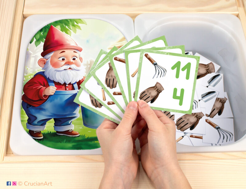 Garden gnome pretend play setup for a matching and counting game. Kids' hands holding task cards displaying numerals and gardening tools. Spring season unit printables for toddlers.