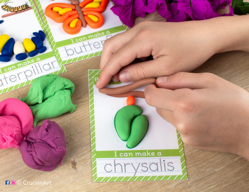 A preschooler is playing with play-doh, molding a chrysalis. Monarch butterfly life cycle unit playdough mats for toddlers fine motor skill development.