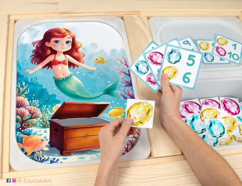 Mermaid's treasure chest worksheet for an educational counting activity inserted into IKEA Flisat table and counters with gems placed in the Trofast bin.