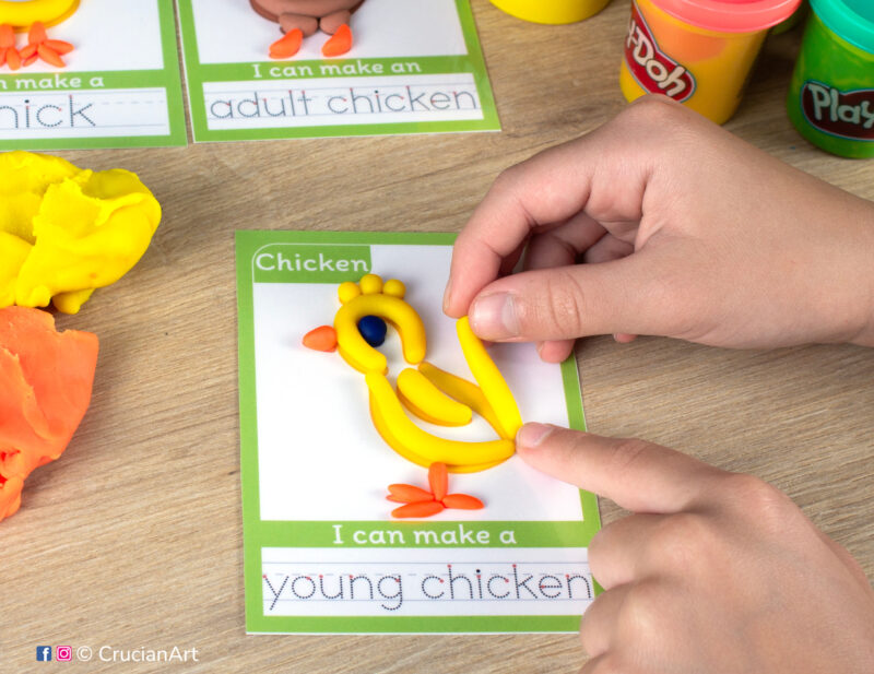 A preschooler is playing with play-doh, molding a chick. Chicken life cycle unit playdough mats for toddlers fine motor skill development.
