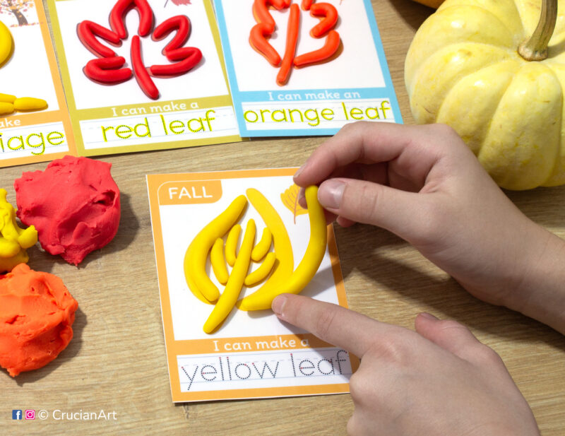 A preschooler is playing with play-doh, molding a yellow leaf. Autumn unit playdough mats for toddlers fine motor skill development.